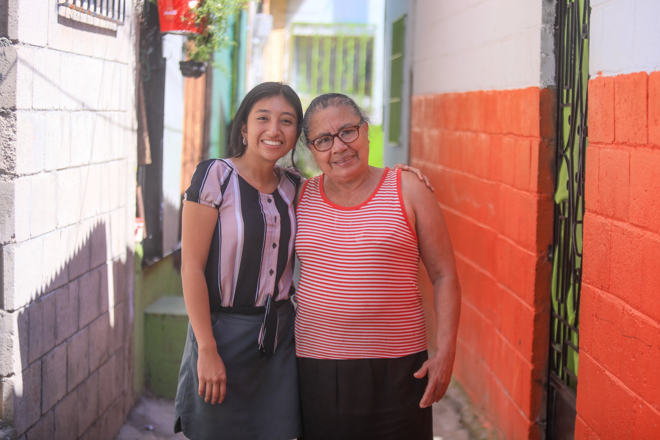 Mujeres posando en un callejón colorido.
